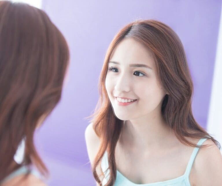 oral care | woman smiling in mirror