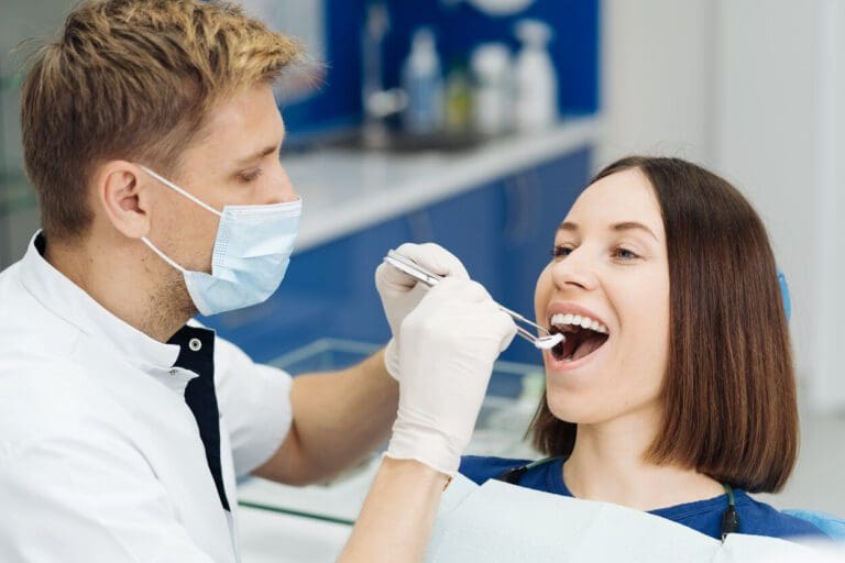 Dentist check patient cavity using instruments at clinic