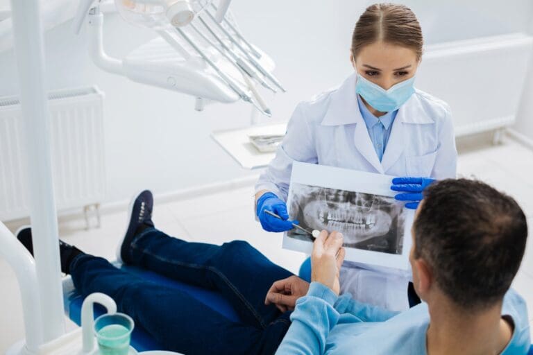 dentist showing patient teeth xray